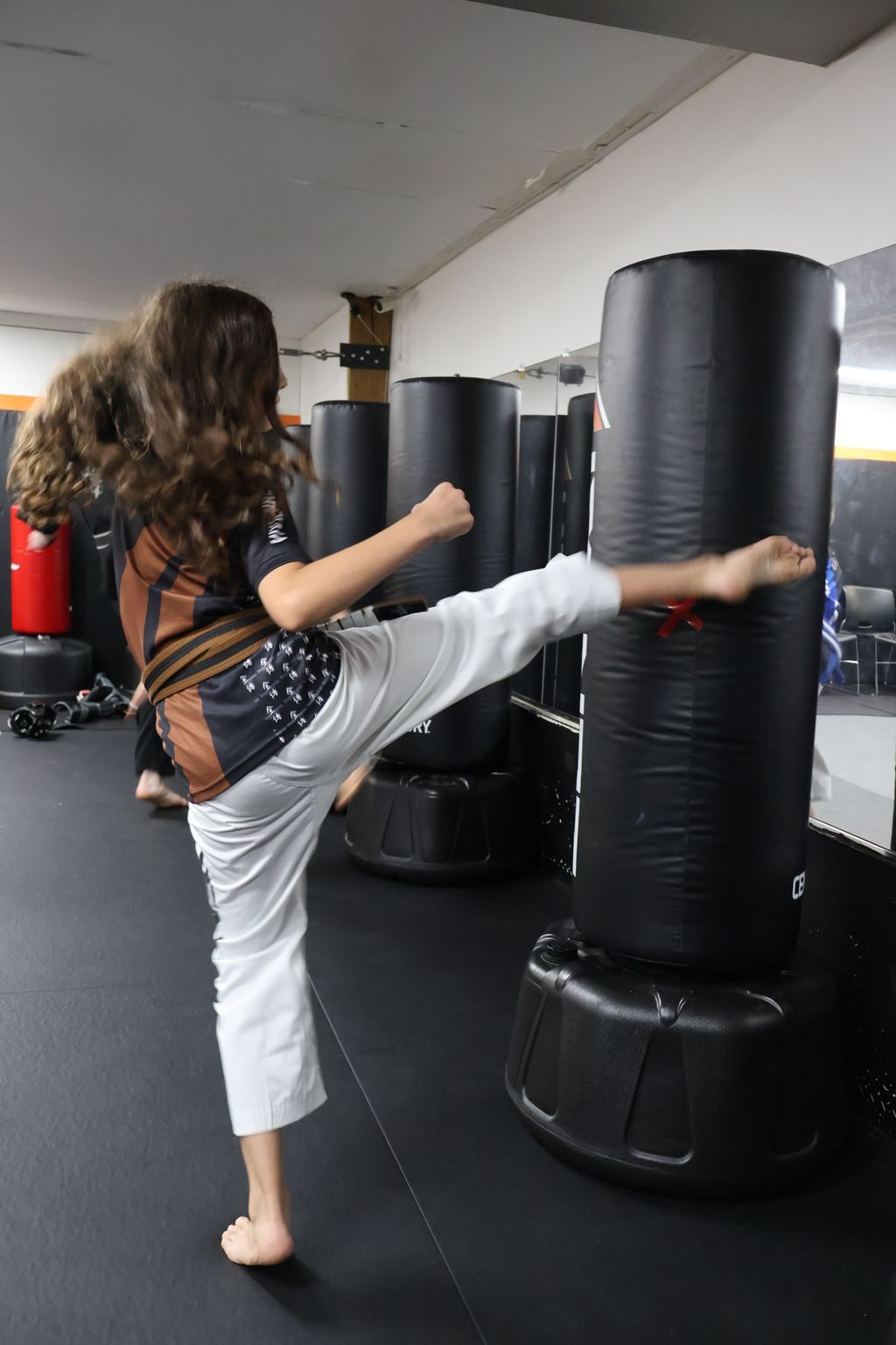 Girl kicking a heavy bag at ZENTAI Martial Arts in North Arlington, NJ