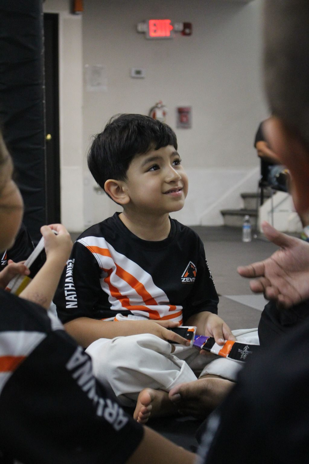 Boy smiling up at his instructor at ZENTAI Martial Arts in North Arlington, NJ