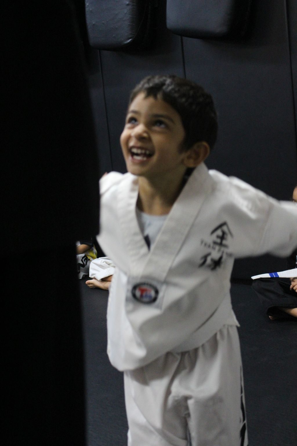 Boy laughing in his white uniform at ZENTAI Martial Arts in North Arlington, NJ