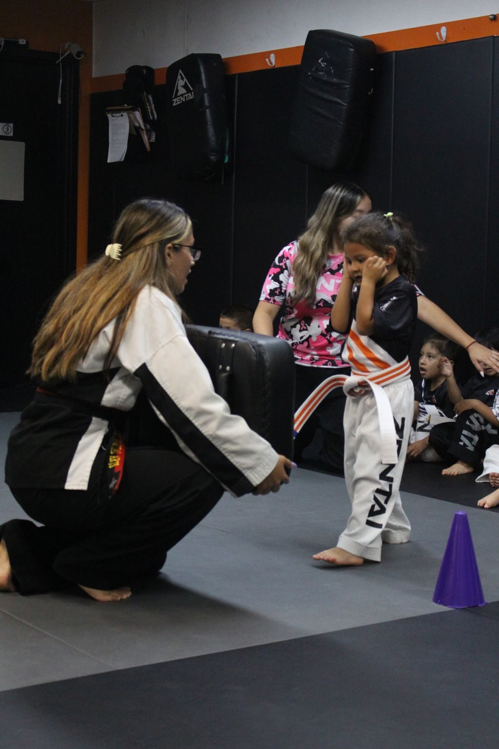 Instructor with a young girl while parents watch at ZENTAI Martial Arts in North Arlington, NJ