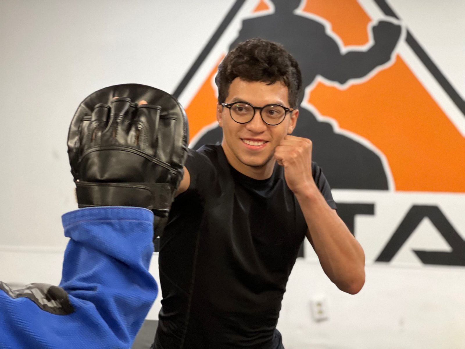 Teen smiling while training with pads at ZENTAI Martial Arts in New Jersey