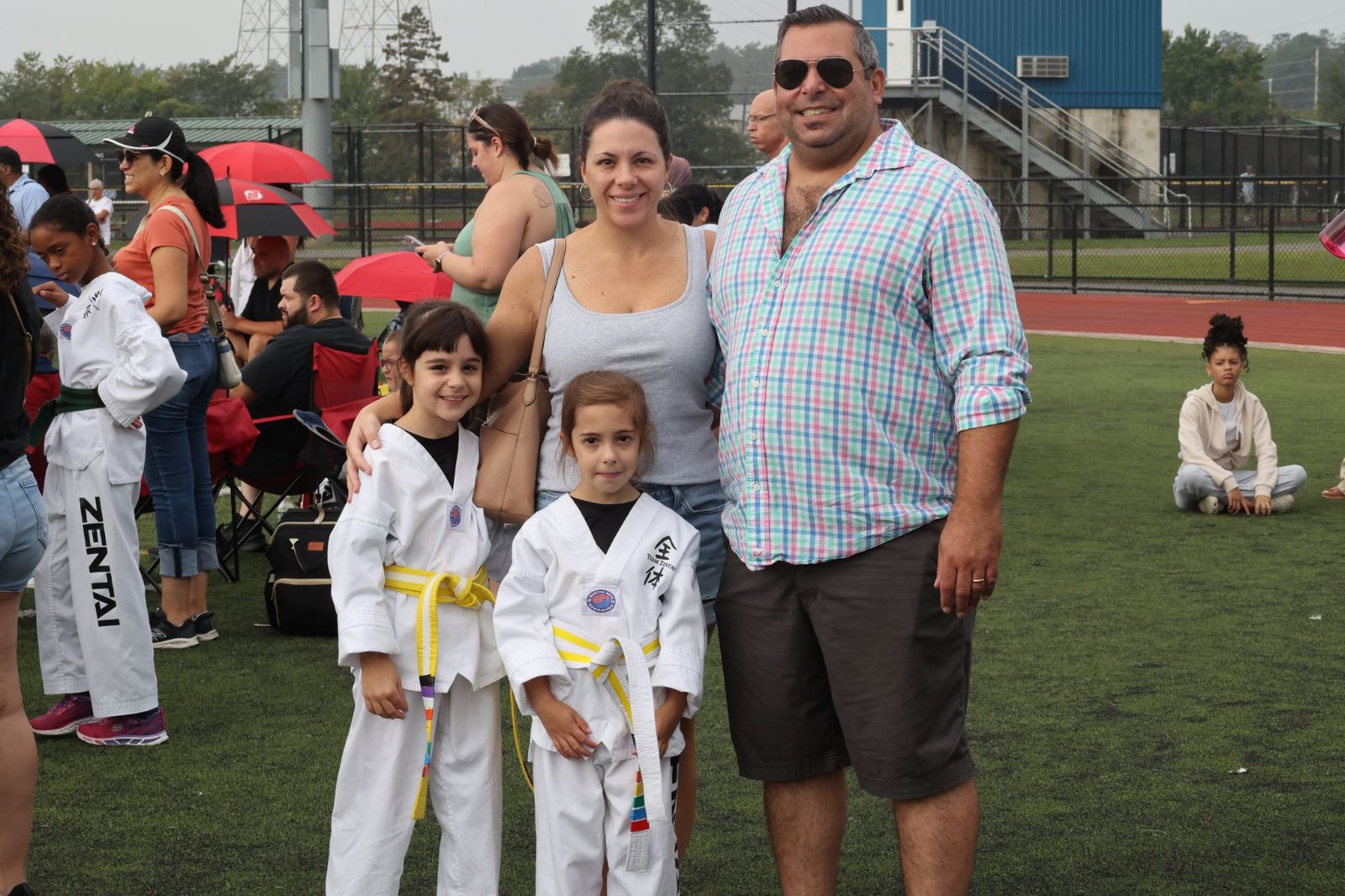 Family photo with kids in uniforms at a ZENTAI Martial Arts belt promotion in New Jersey