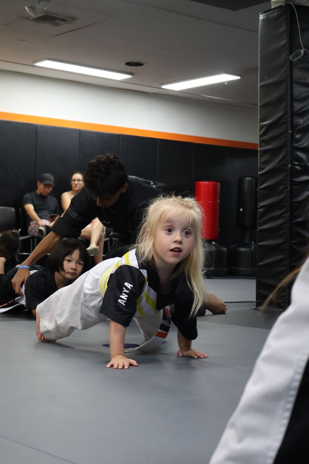 Instructor guiding a little girl through a crawl at ZENTAI Martial Arts in North Arlington, NJ