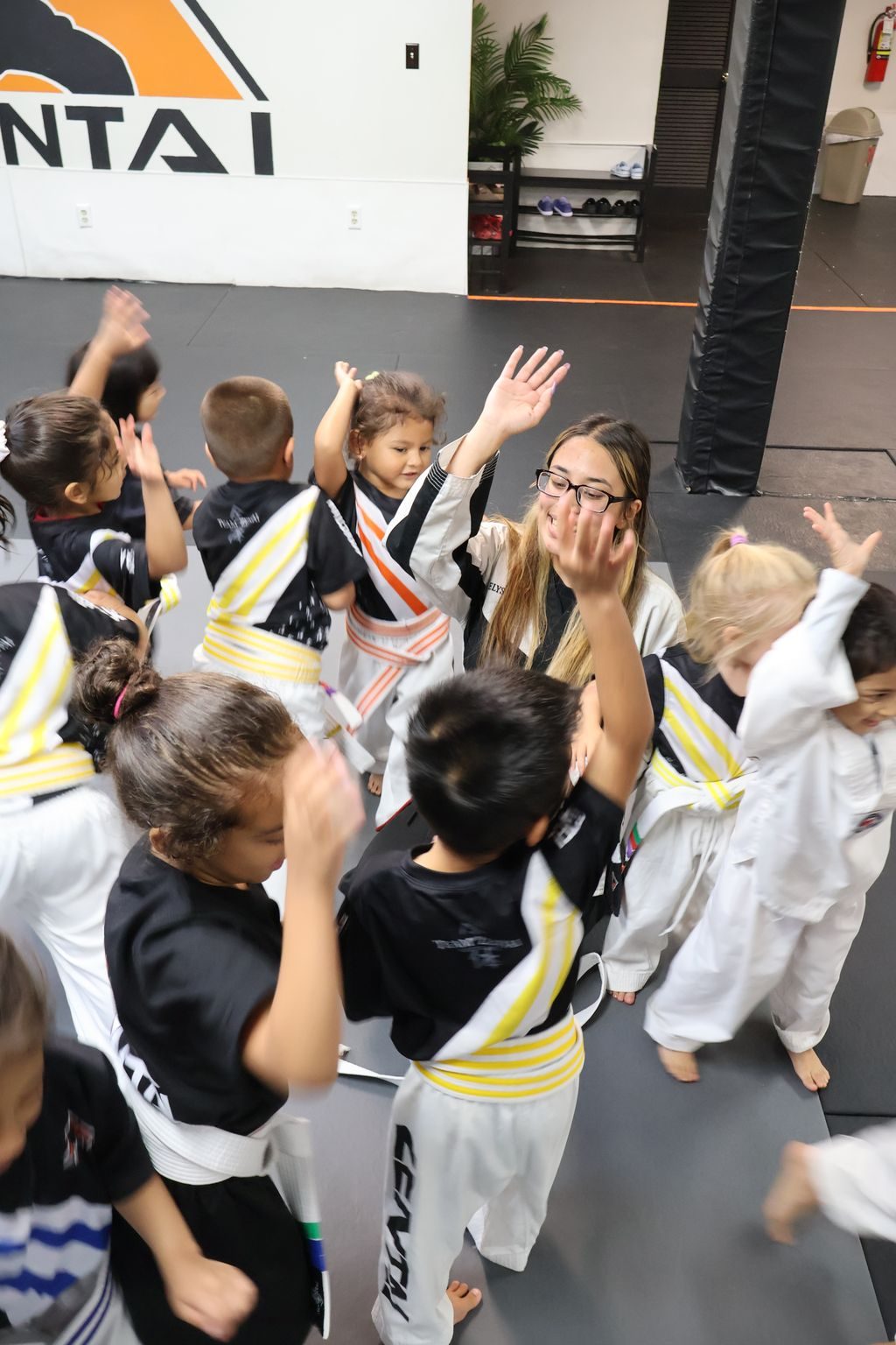 Kids and instructor celebrating with high fives at ZENTAI Martial Arts in North Arlington, NJ