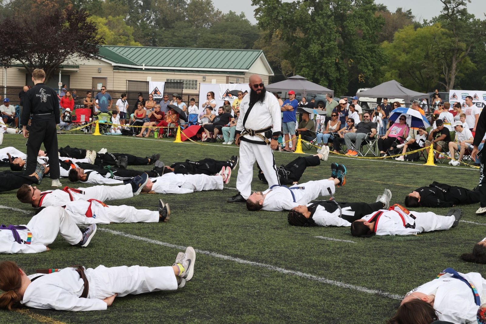 Students stretching together on the grass at the ZENTAI Mega Belt Promotion in New Jersey