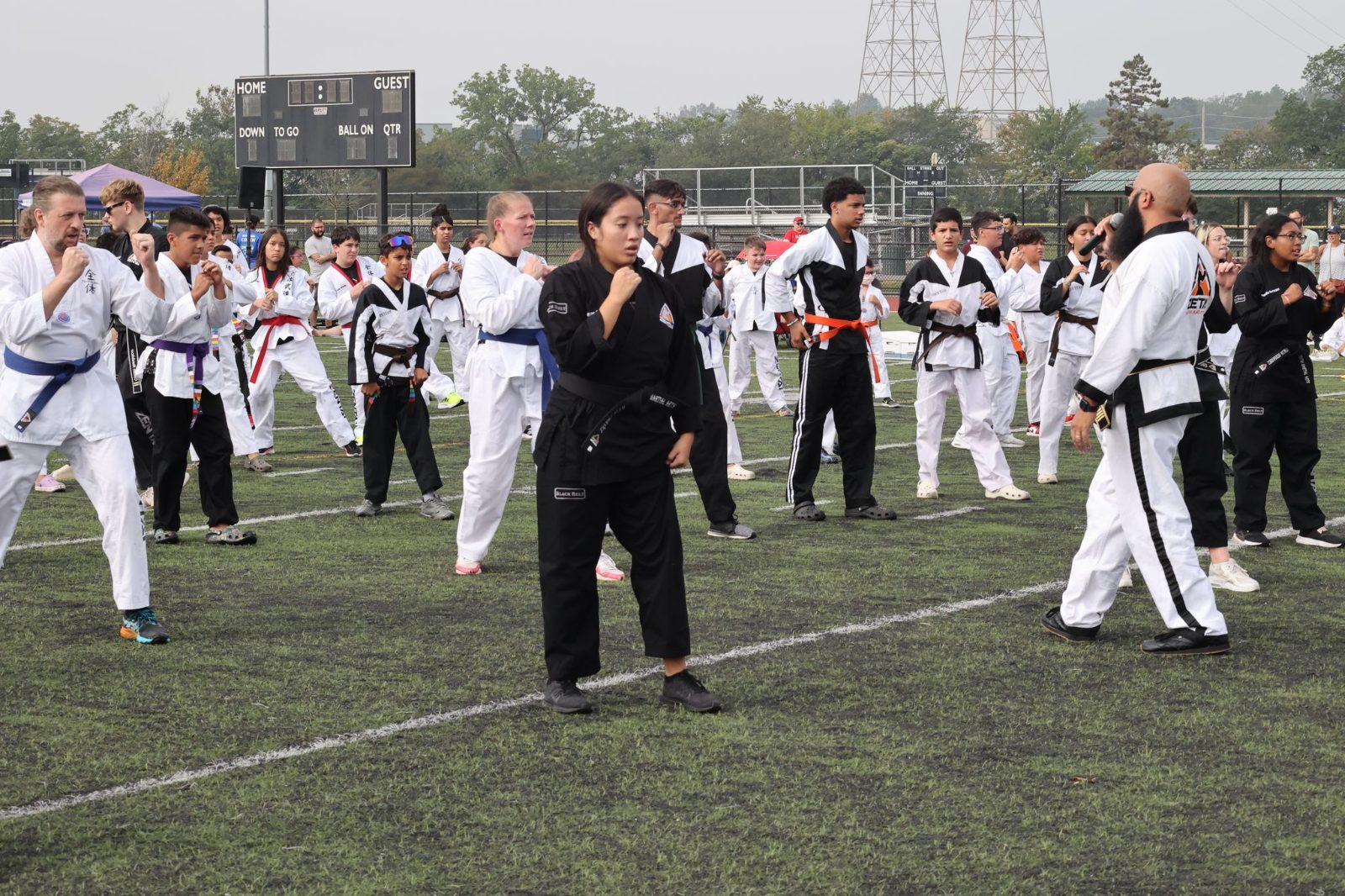 Students practicing kicks together on the field at the ZENTAI Mega Belt Promotion in New Jersey