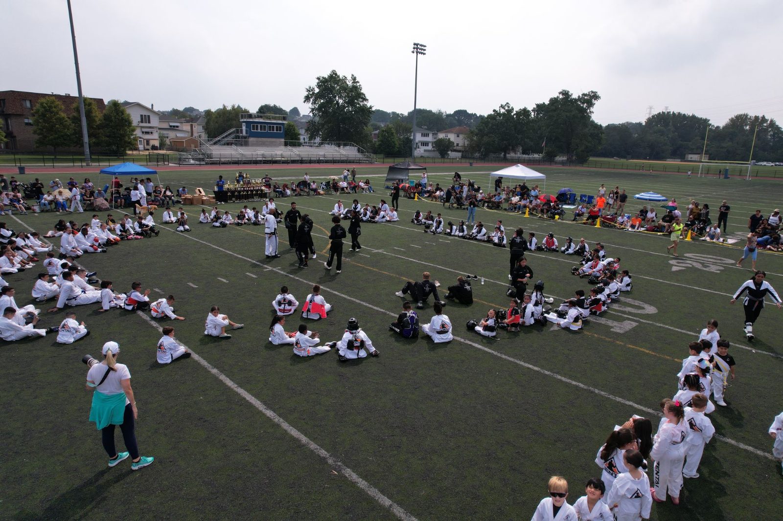 Students seated in a big circle on the field at the ZENTAI Mega Belt Promotion in New Jersey