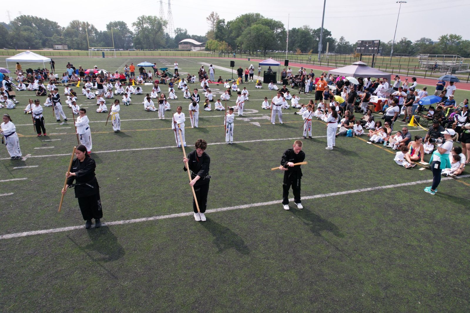 Black belts leading a large group on the field at the ZENTAI Mega Belt Promotion in New Jersey
