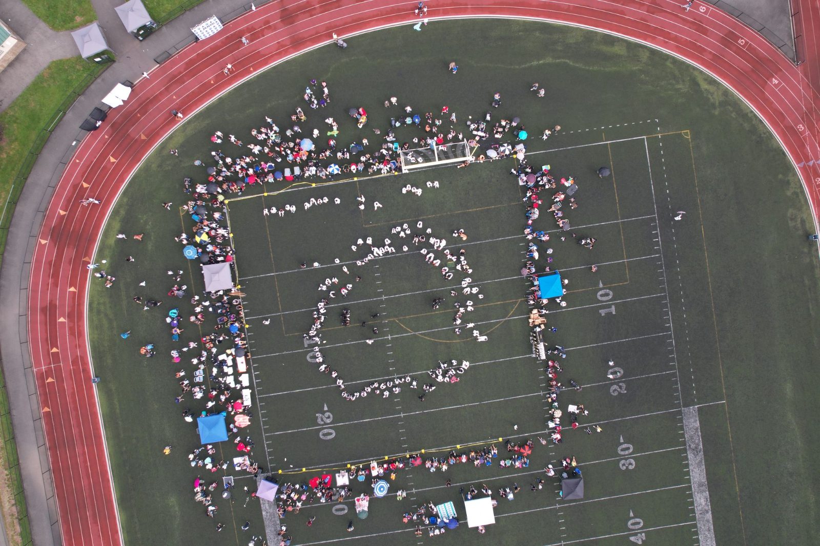 Aerial view of hundreds of students on the track field at the ZENTAI Mega Belt Promotion in New Jersey
