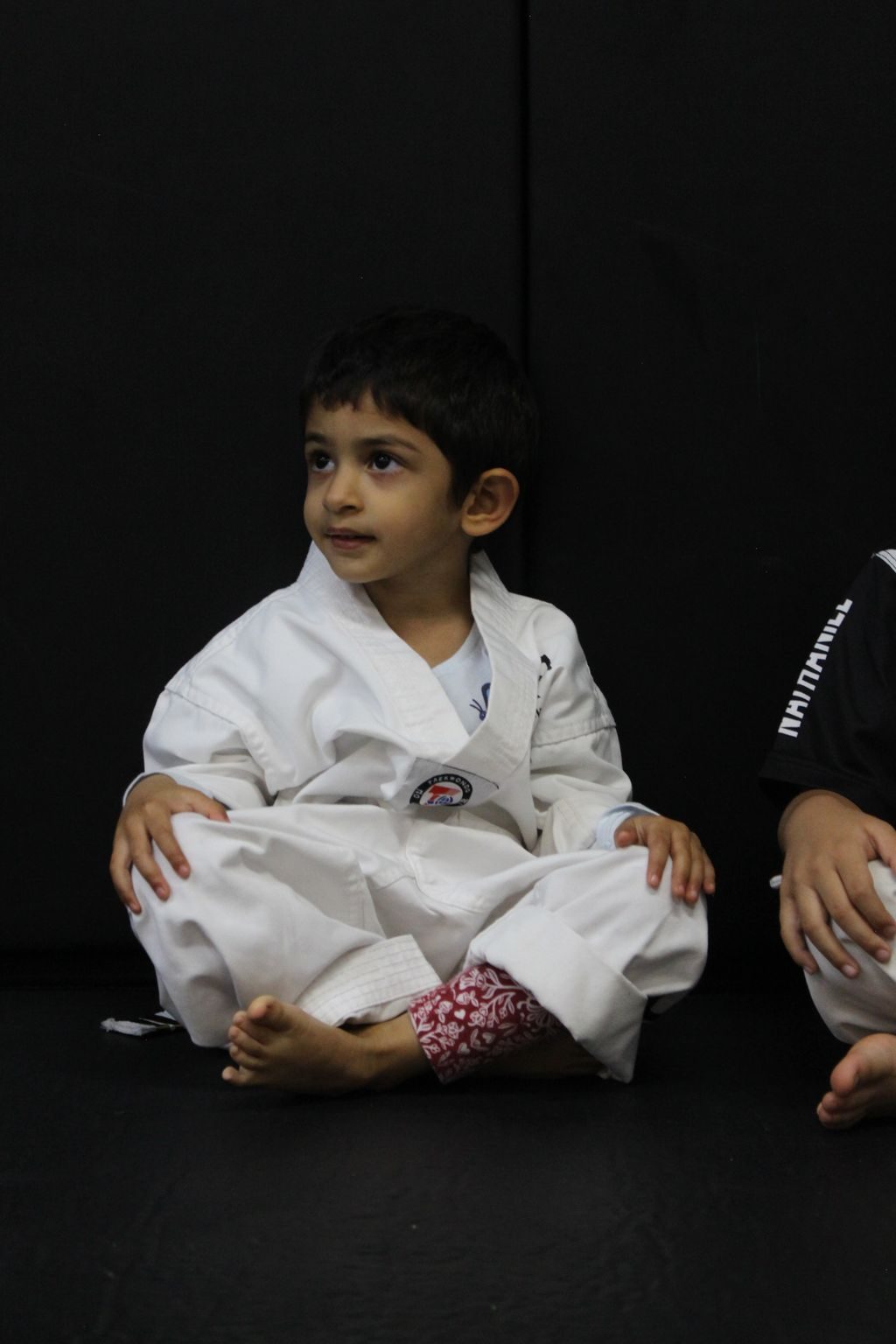 Young boy smiling in his white uniform at ZENTAI Martial Arts in North Arlington, NJ