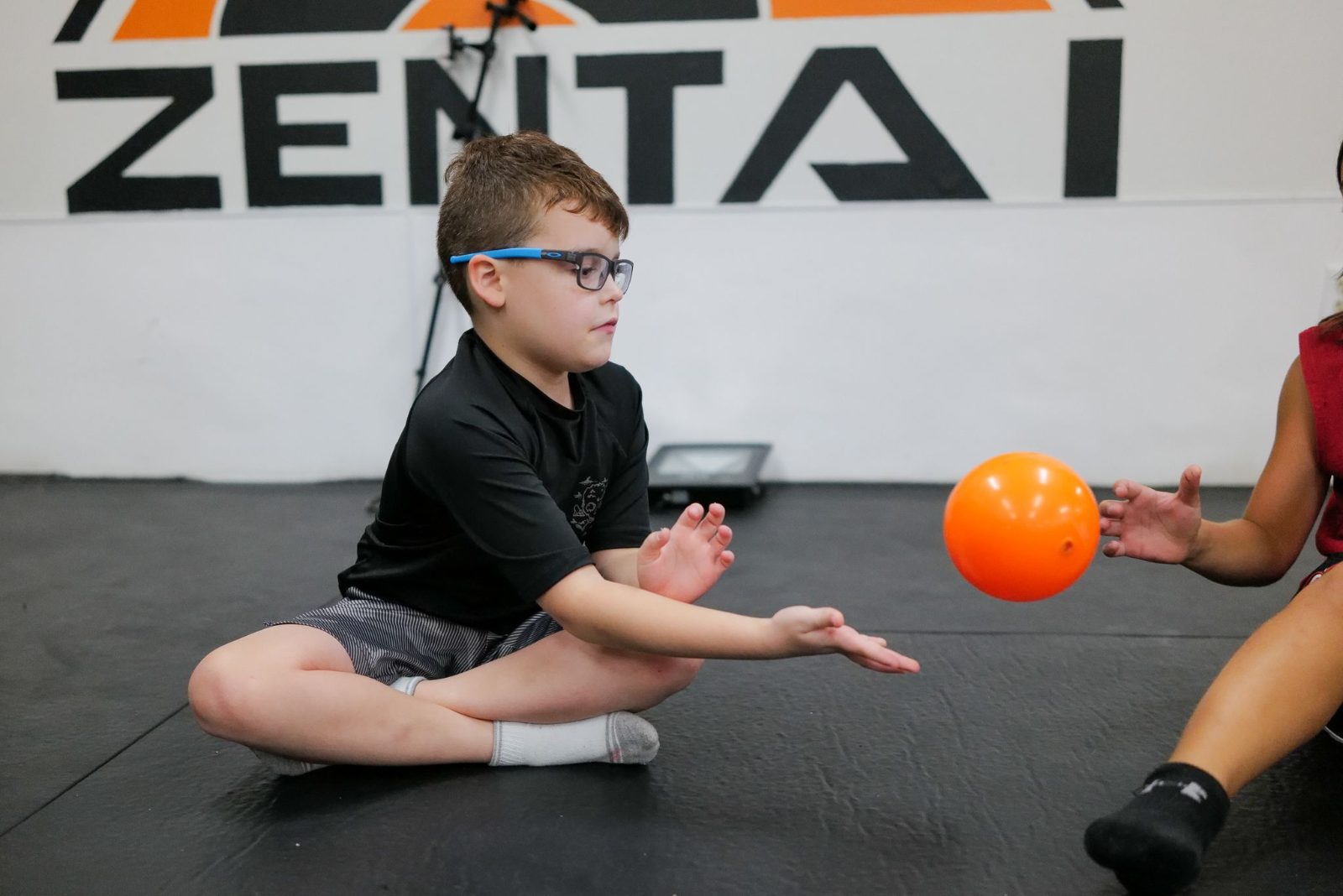 Boy rolling a ball during a game at ZENTAI summer camp in New Jersey