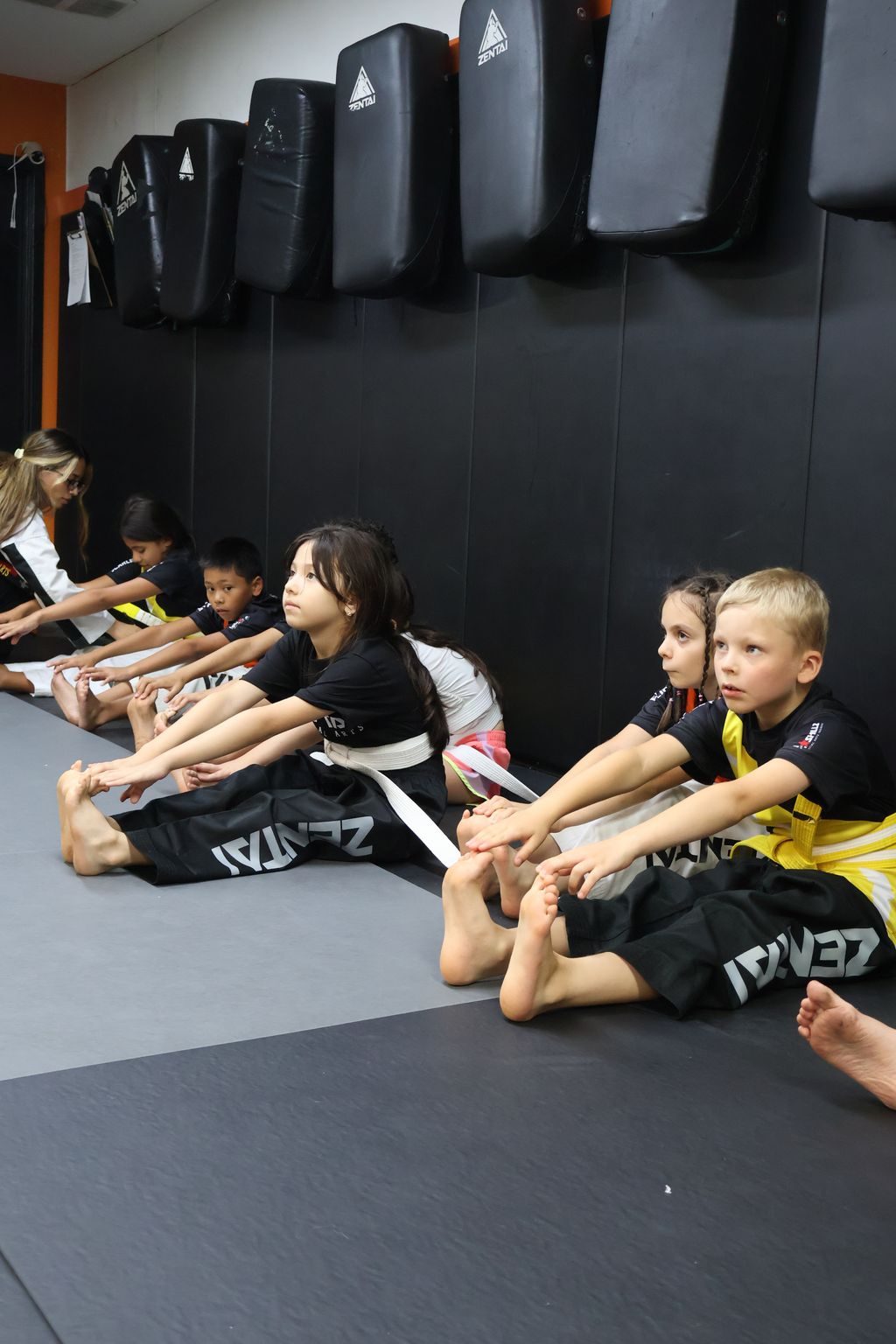 Kids seated in a row stretching at ZENTAI Martial Arts in North Arlington, NJ