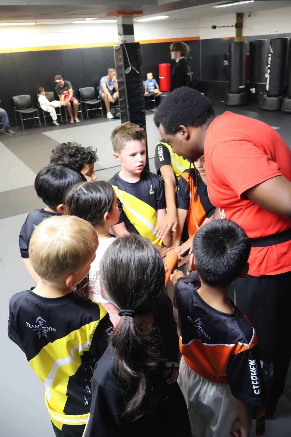Kids in a huddle, seen from behind at ZENTAI Martial Arts in North Arlington, NJ