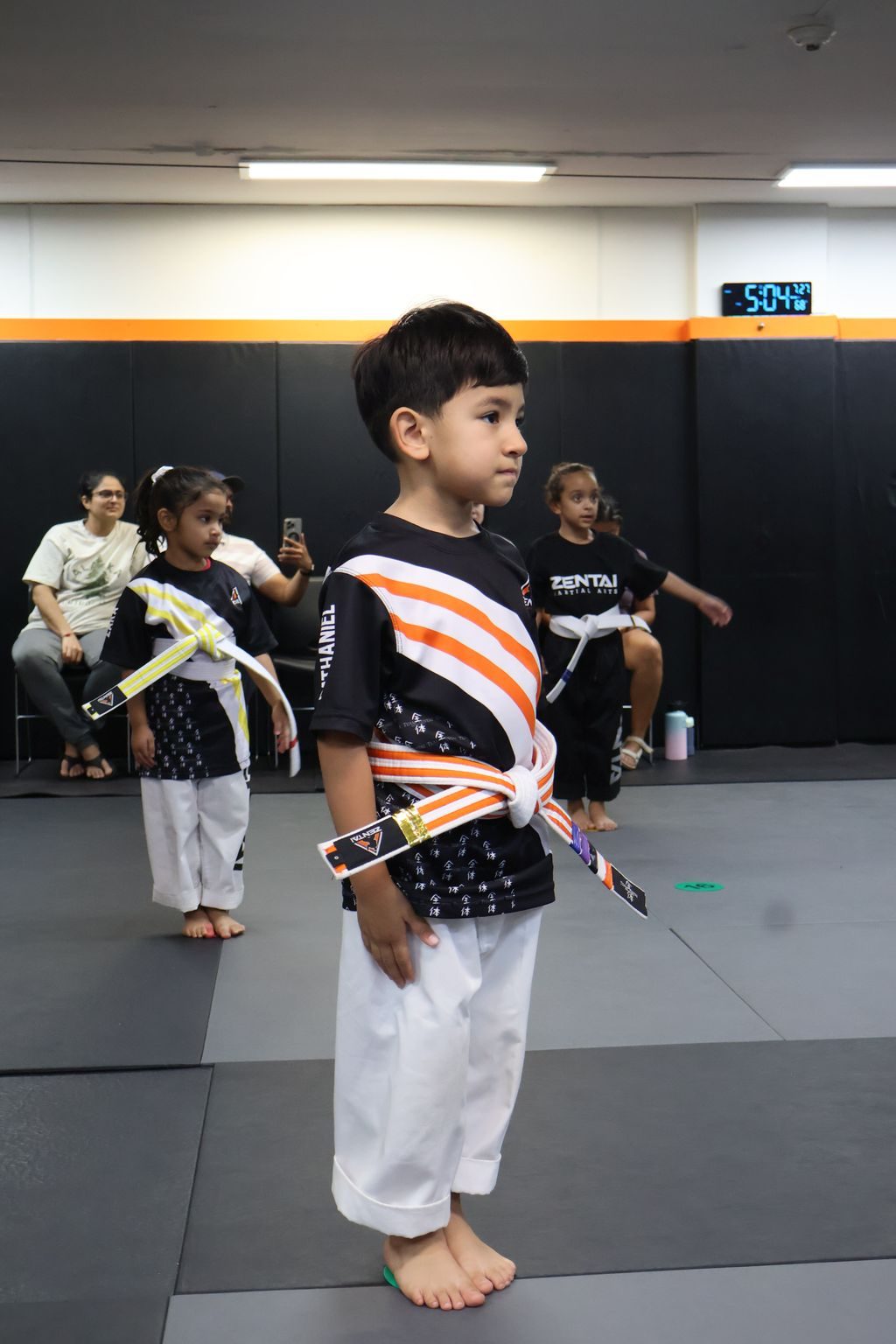 Boy standing proudly in his uniform at ZENTAI Martial Arts in North Arlington, NJ