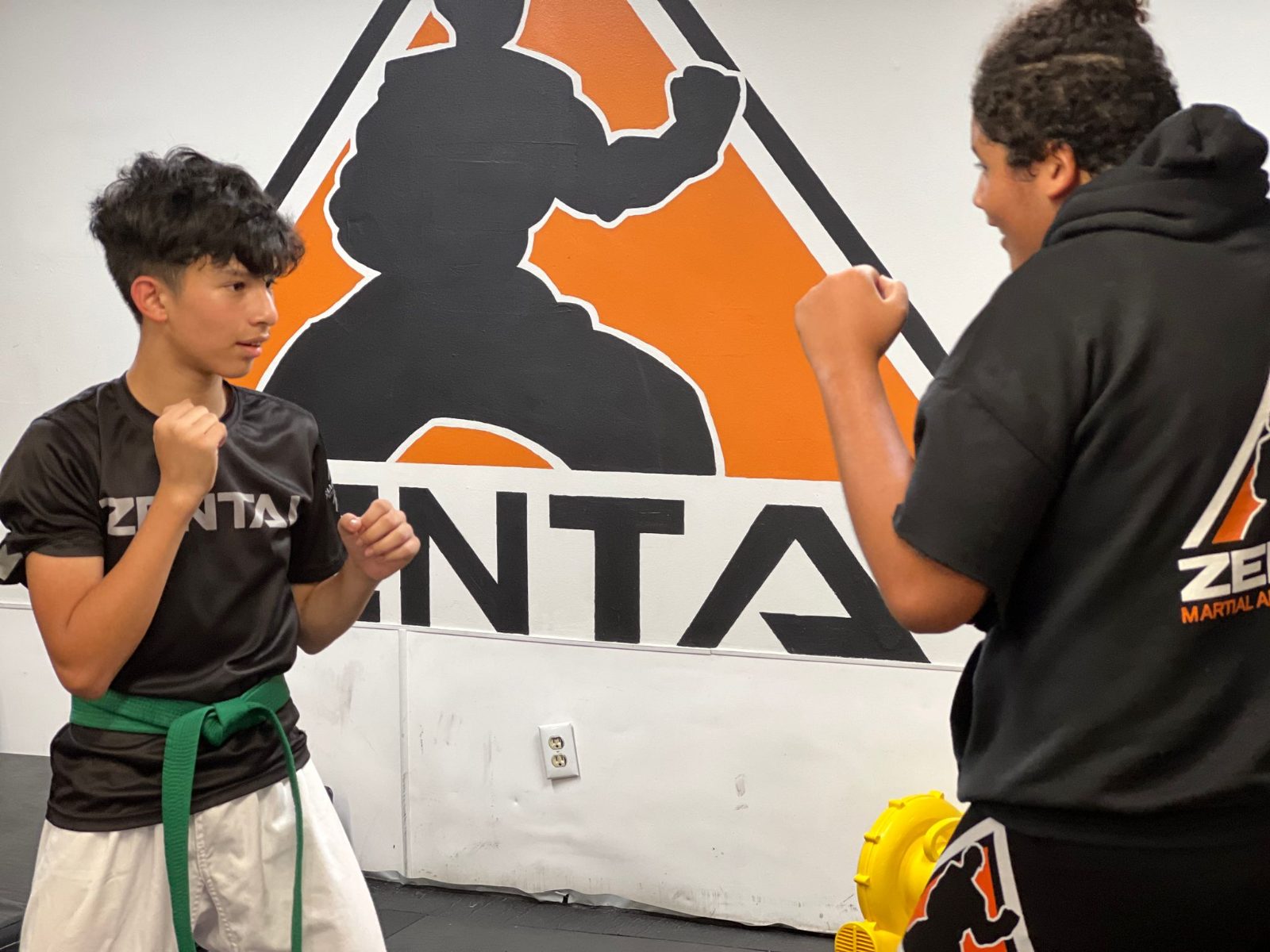 Teen practicing in front of the ZENTAI logo at ZENTAI Martial Arts in New Jersey